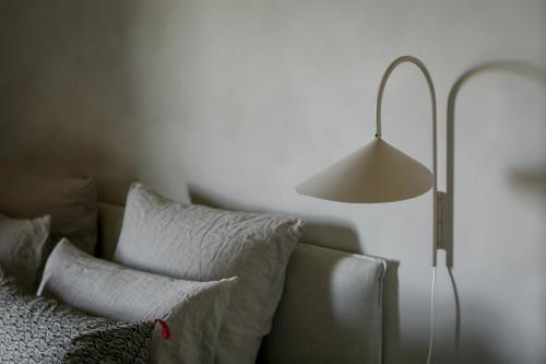 a lamp sitting next to a couch with pillows at Mas des Prêcheurs in Tarascon