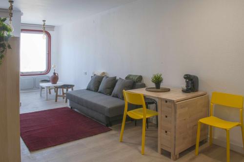 a living room with a couch and a table and chairs at Manzaneda Natura Apartaments T1 vista montaña in Prada