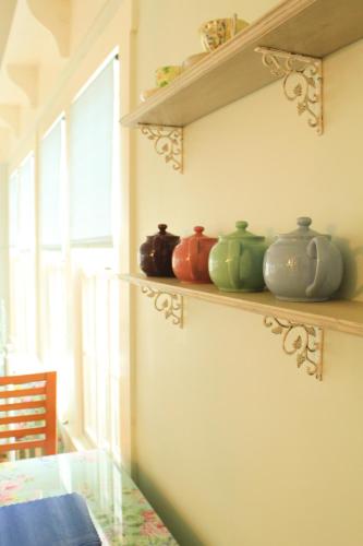 a row of vases sitting on a shelf in a room at An English Garden in Dennis Port