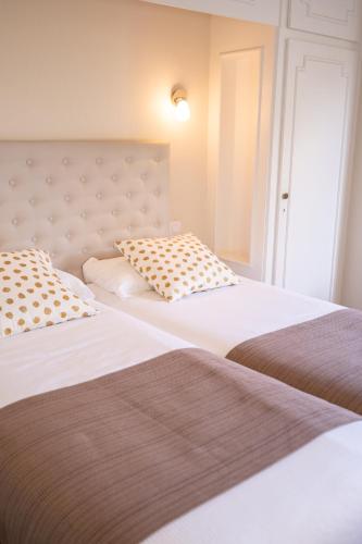 two beds sitting next to each other in a room at The Originals City, Hôtel Mondial, Perpignan in Perpignan