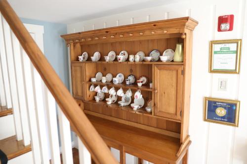a stair case with a bunch of bowls on a shelf at An English Garden in Dennis Port