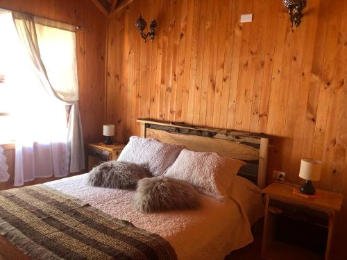 ein Schlafzimmer mit einem Bett mit zwei Kissen darauf in der Unterkunft Cabaña 1 Crucerito in Castro