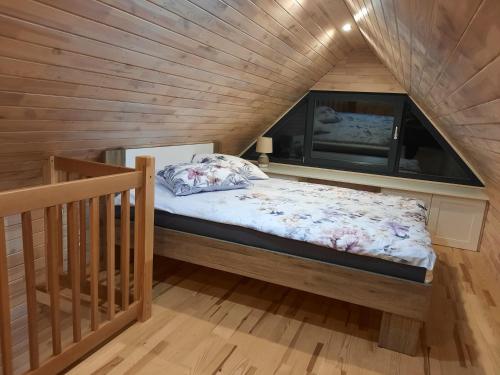 a bed in a room with a wooden ceiling at Domek na korcie in Lubomierz