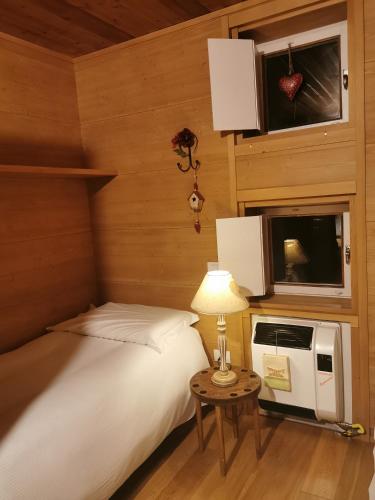 a bedroom with a bed and a table with a lamp at Chalet nel bosco in Borca di Cadore