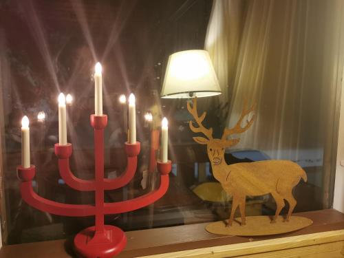 a red candle holder with a deer in front of it at Chalet nel bosco in Borca di Cadore