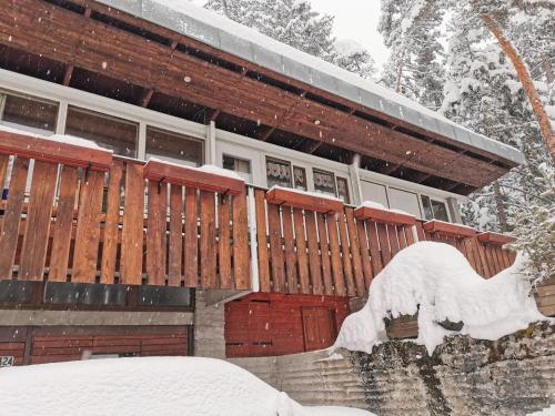 a building covered in snow with a statue in front of it at Chalet nel bosco in Borca di Cadore