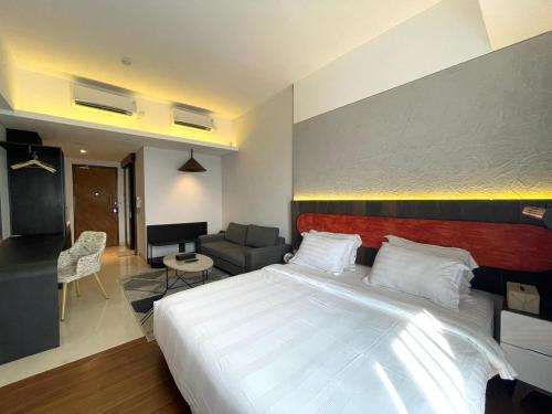 a bedroom with a large bed and a living room at Ruby Apartment #4 in Kejayan