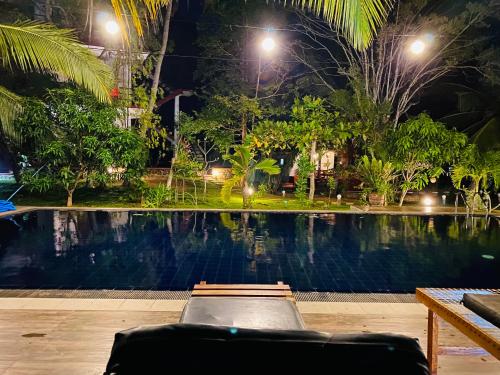 a suitcase sitting next to a swimming pool at night at Hidden Garden Tangalle in Tangalle