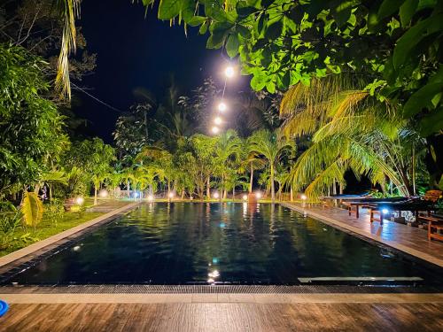 a swimming pool in a park at night at Hidden Garden Tangalle in Tangalle