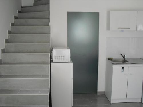 a kitchen with a staircase and a laptop on a counter at Petit coin de paradis. in Six-Fours-les-Plages