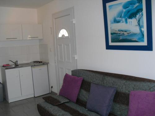 - un salon avec un canapé et des oreillers violets dans l'établissement Petit coin de paradis., à Six-Fours-les-Plages