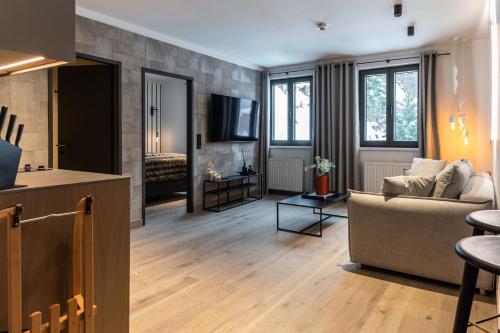 een woonkamer met een bank en een open haard bij Residenz Boutique Suites in Bad Gastein