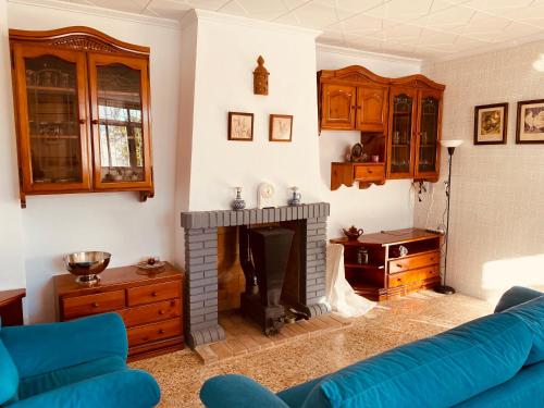 ein Wohnzimmer mit einem blauen Sofa und einem Kamin in der Unterkunft Casa Mayor in Tous