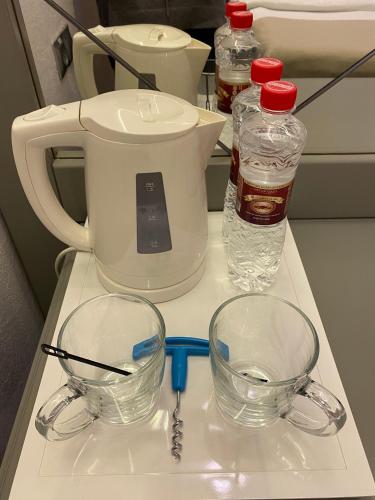 a counter with two glass bowls and bottles of water at Spa-Hotel Myslyvskiy Dvir in Kyiv