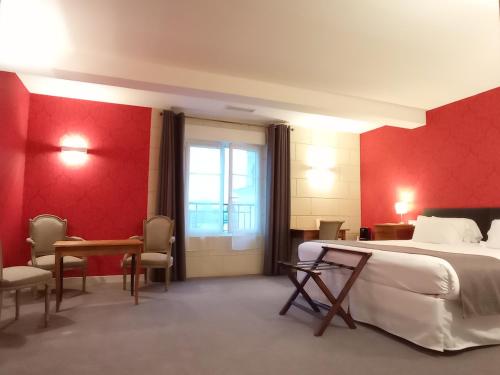 a hotel room with a bed and a table and chairs at Hôtel Grand Monarque in Azay-le-Rideau