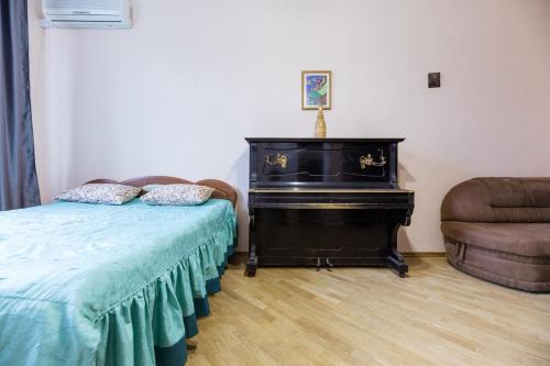 キーウにあるApartment with lovely viewのピアノ、ベッド、椅子が備わるベッドルーム1室が備わります。