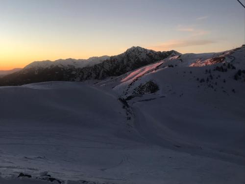 a snow covered mountain with the sunset in the background at le pragmatique in Guillestre