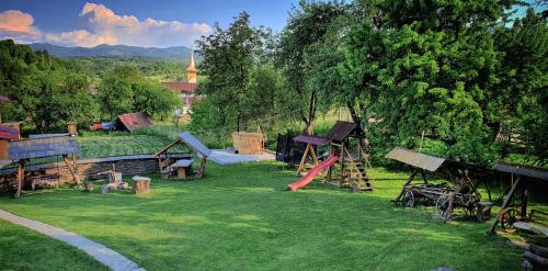 a park with a playground with a slide at Pensiunea Maramu in Breb