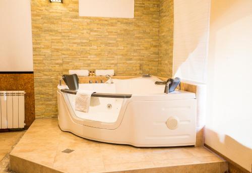 a bath tub sitting in a bathroom with a sink at Spa-Hotel Myslyvskiy Dvir in Kyiv