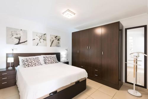ein Schlafzimmer mit einem großen Bett und Holzschränken in der Unterkunft Casachayofita in Costa Del Silencio