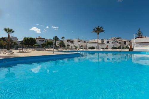 ein großer blauer Pool mit Gebäuden im Hintergrund in der Unterkunft Casachayofita in Costa Del Silencio