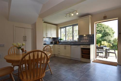 a kitchen with a table and a table and chairs at Maytham Cottage in Rye