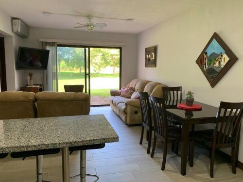 a living room with a couch and a table and chairs at Apartamento Ganesha Liberia in Santa Ana