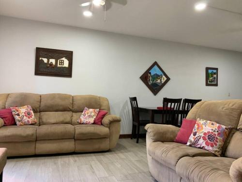 a living room with two brown couches and a table at Apartamento Ganesha Liberia in Santa Ana