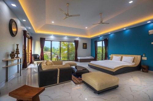 a bedroom with a bed and a living room with a couch at SaffronStays Aura, Alibaug - luxury pool villa with a game room and spacious lawn in Alibaug