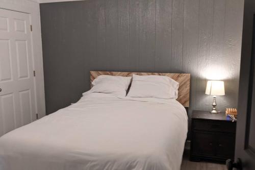 a bedroom with a large white bed with a lamp at Cabin 3 - Modern Cabin Rentals in Southwest Mississippi at Firefly Lane in Summit