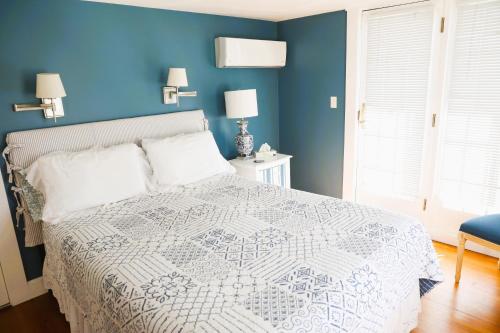 a bedroom with a bed with a blue wall at An English Garden in Dennis Port