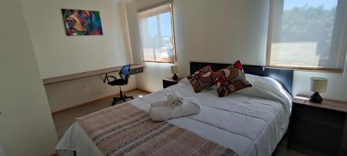 a bedroom with a large bed with white sheets and pillows at APART HOTEL EN BULNES in Bulnes