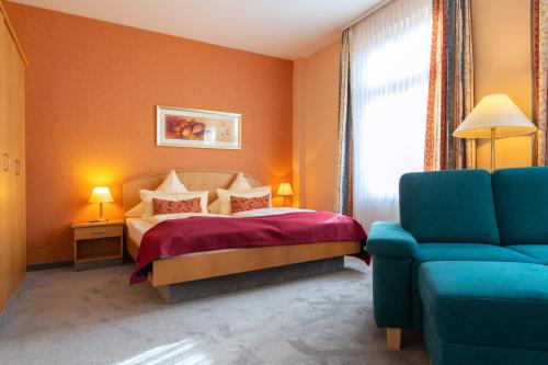 ein Schlafzimmer mit einem Bett und einem blauen Stuhl in der Unterkunft Dappers Wellness Hotel in Bad Kissingen