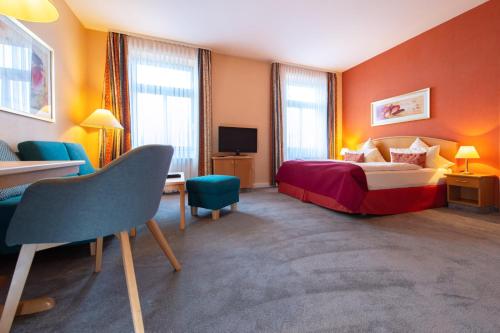 Habitación de hotel con cama y TV en Dappers Wellness Hotel, en Bad Kissingen