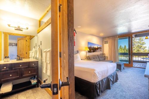 a bedroom with a bed and a bathroom with a sink at Hotel Style Room in The Timber Creek Lodge condo in Truckee
