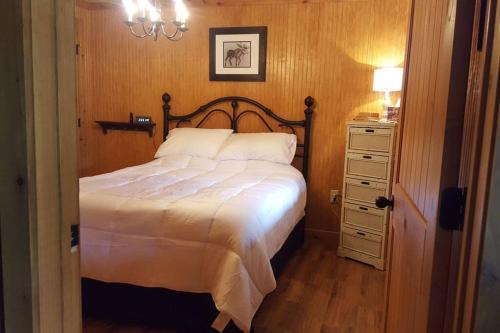 a bedroom with a bed and a dresser with a lamp at Cabin 2 - Modern Cabin Rentals in Southwest Mississippi at Firefly Lane in Summit