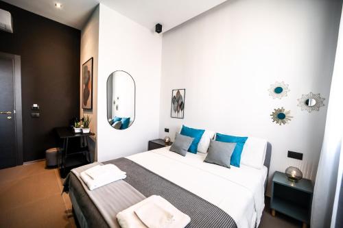 a bedroom with a large bed with blue pillows at Materdays 24 in Naples