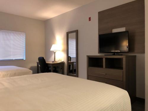 a hotel room with a bed and a flat screen tv at GreenTree Inn Denver Tech Center in Centennial