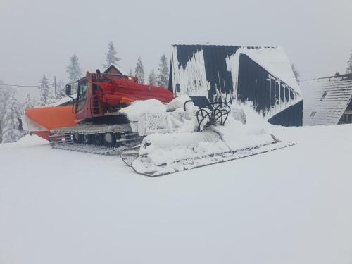 a bulldozer covered in snow next to a building at Casa Valley Paradiso - Jahorina in Jahorina