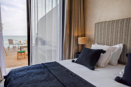 sypialnia z łóżkiem i widokiem na ocean w obiekcie Hôtel Oasis Dakhla w mieście Dakhla