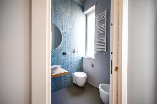 a bathroom with a toilet and a sink and a window at Materdays 24 in Naples