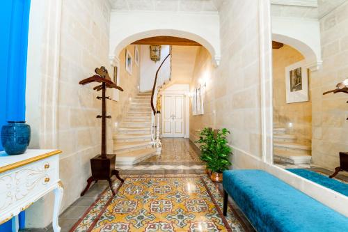 a hallway with a staircase and a blue couch at Monreal Boutique Townhouse - R024RM4 in Paola