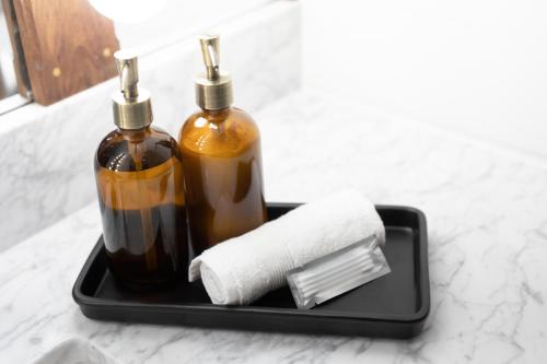 two bottles of soap and a roll of toilet paper on a tray at Surf Hotel & Chateau in Buena Vista