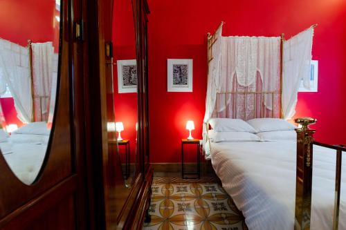 a bedroom with red walls and a bed with white sheets at Monreal Boutique Townhouse - R024RM4 in Paola