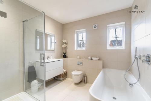 a bathroom with a tub and a toilet and a shower at LUXURY HOME - CENTRAL WINDSOR, GATED PARKING in Windsor
