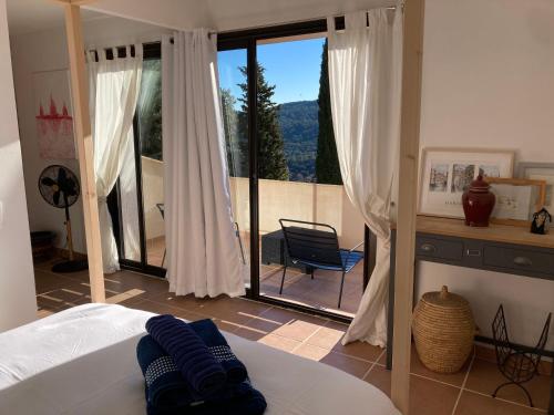 um quarto com uma cama e vista para uma varanda em Villa les écureuils em Fréjus