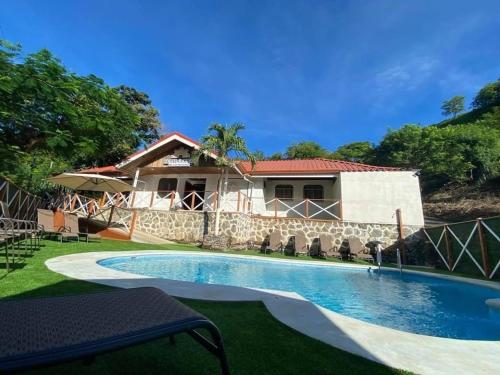 a villa with a swimming pool in front of a house at Hotel Ocotal Bed & Breakfast in Ocotal