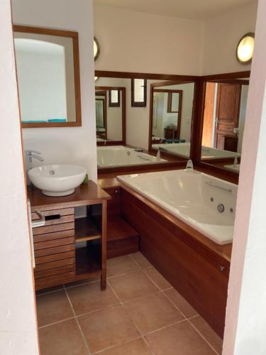 a bathroom with two sinks and a tub and mirrors at Villa les écureuils in Fréjus