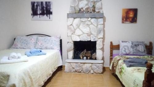 a bedroom with two beds and a fireplace at Argiris Old City House 1 in Kalabaka