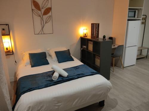 una camera da letto con letto con cuscini blu e scrivania di Villa Raphaëlle #2 Centre ville avec parking a Le Havre
